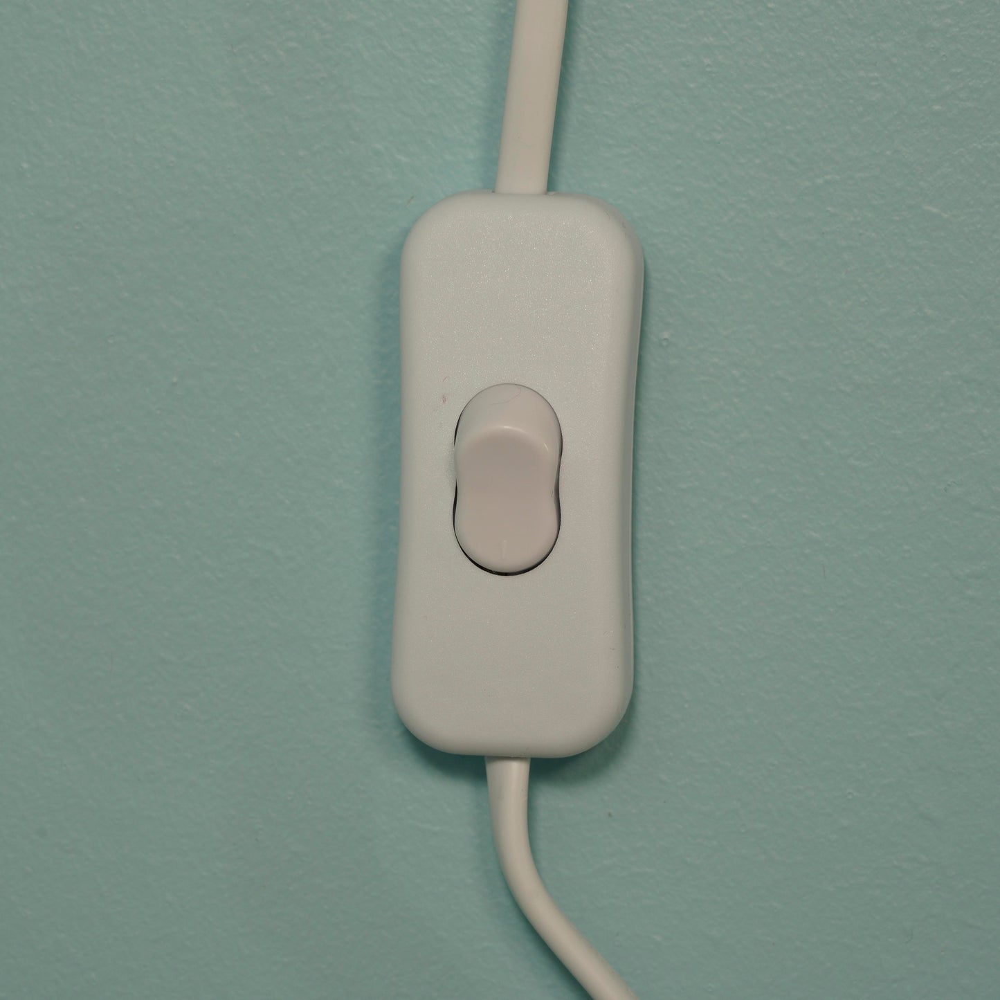 White wall switch on a light blue wall